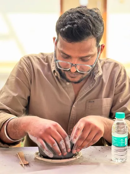 Trading hypotheses for handprints. This scientist is completely absorbed in the tactile process of moulding his first piece of pottery.