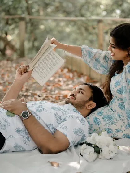 A different angle of the same picnic scene, with the groom resting his head on the bride's lap. This playful and loving interaction makes for a charming and authentic portrait.
