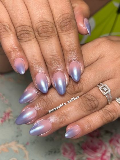 A beautiful chrome ombré effect. The nails transition from a natural nude base to a pearlescent lavender chrome at the tips, creating a dreamy and ethereal look.