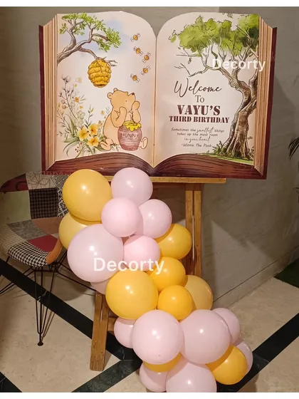 A creative welcome sign designed as an open storybook for Vayu's Winnie the Pooh party.