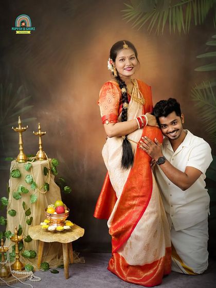 A playful and loving pose where the dad-to-be rests his head on the baby bump. This captures the couple's joy and connection within the beautiful context of their traditional attire.