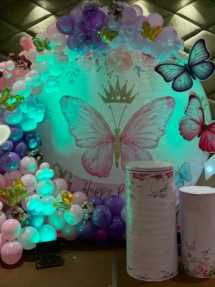 The lighting can completely change the mood of the decor. Here's the same butterfly setup with a cool-toned light, highlighting the purple and blue shades in the balloon arrangement.