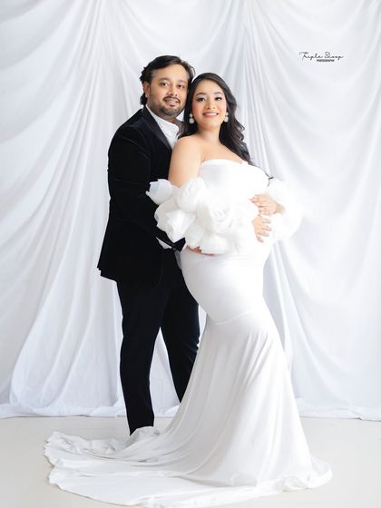 This couple radiates pure elegance. The mom-to-be's white gown and the dad-to-be's black velvet jacket create a sophisticated, classic Hollywood feel.