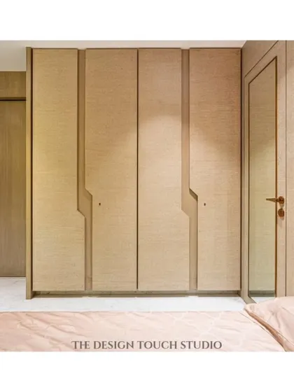 A view of the custom wardrobe with its unique groove handles, designed to complement the room's modern aesthetic. The integrated mirror adds practicality and enhances the sense of space.