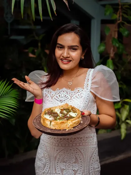 A guest proudly presents her Puffizza, a dish that brings smiles and a taste of nostalgia to our mansion.