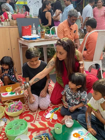 An artist engages with children in a craft session during one of our early events. We've always been a space for all ages to come together, play, and create.