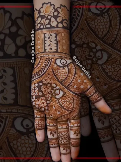 A classic Indian mehendi design with peacock and floral elements. The filled fingertips are a traditional touch that many brides love.