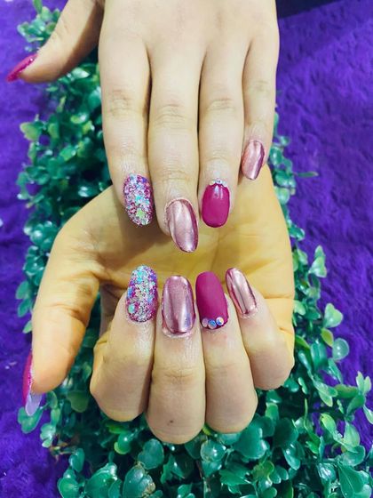 A fun and sparkly set combining a magenta chrome finish with a full-coverage multi-color glitter accent nail.