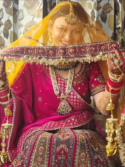 The playful "ghoonghat" shot. This image shows how the makeup holds up and looks beautiful even in traditional poses, with the focus on the bride's happy eyes.