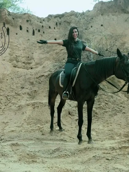 A rider spreads her arms wide, embracing the freedom of the open trail. This image captures the feeling of liberation and joy that comes with exploring nature on horseback.