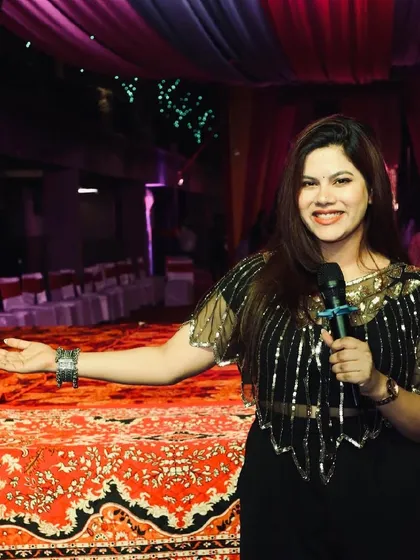 On the stage at the Dandiya event, inviting everyone to join the fun.