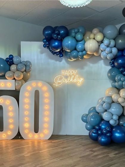 The full 50th birthday setup, showcasing the impressive scale of the light-up numbers and the L-shaped balloon garland that perfectly frames the corner of the room.
