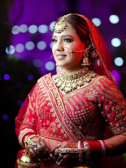 A beautiful three-quarter length bridal portrait, showcasing her entire jewelry set and the rich color of her lehenga.