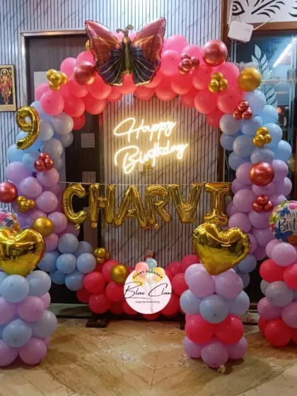 A colorful balloon arch with heart and butterfly foils for a 9th birthday party.