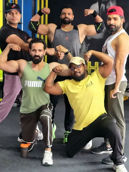 Strong people don't put others down, they lift them up. Our team of trainers and dedicated members flexing together.