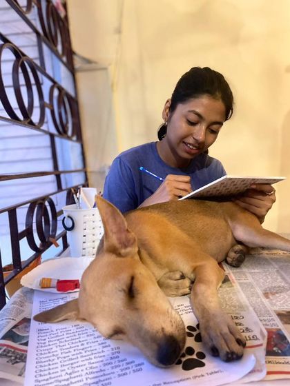 A sleepy puppy rests its head on a participant's art table, becoming a part of the creative process.