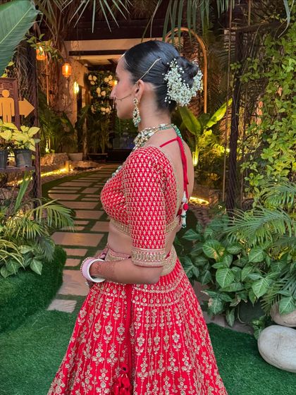 A side profile of a bride with a floral bun, showing how it complements her traditional attire.