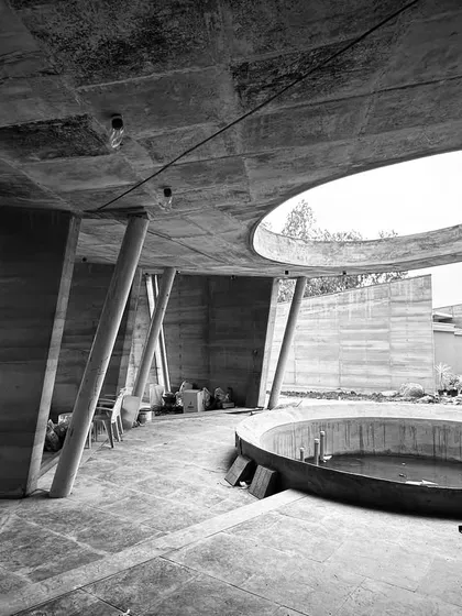 An ode to raw form and tactile beauty. This black and white detail of a resort under construction reveals the poetry of its structure, with tilted concrete columns and a circular oculus that frames the sky, demonstrating our command of bold, site-responsive geometry.