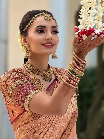A beautiful portrait of the bride with traditional flower garlands. The makeup is fresh and vibrant, perfect for the ceremony.