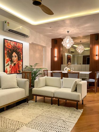 This living room has a warm, tropical feel. We combined neutral sofas with a vibrant piece of wall art and natural wood tones to create an inviting atmosphere that feels like a personal oasis.