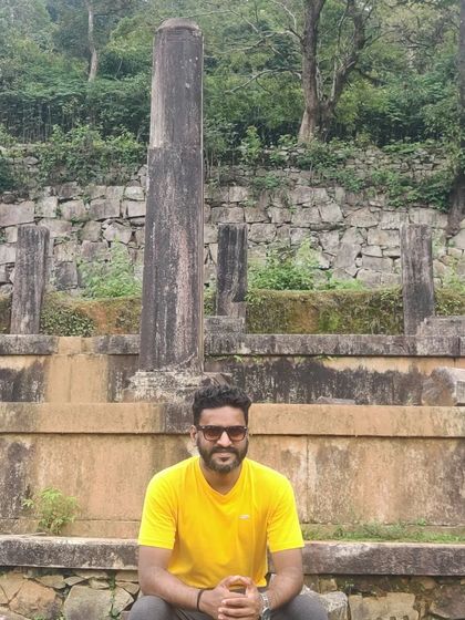 A trekker sitting amidst the ancient ruins of a fort.
