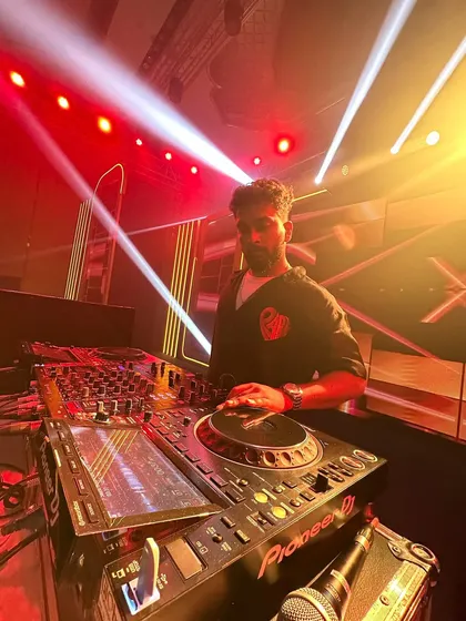 A shot of me under intense red and yellow lights, fully absorbed in the mix. The heat of the lights matches the energy of the set.