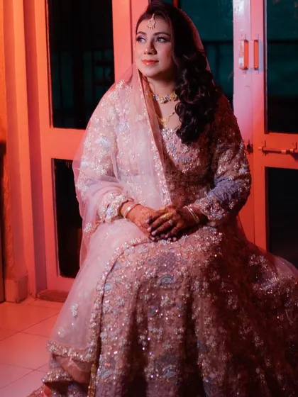 A thoughtful moment captured beautifully. This image highlights the intricate details of her Walima gown and the soft, elegant makeup that complements it perfectly.