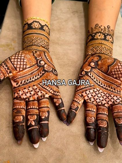 A bolder, more geometric design for a family member who wants a modern yet traditional look. The contrasting patterns and dark fingertips make this a striking choice for any celebration.