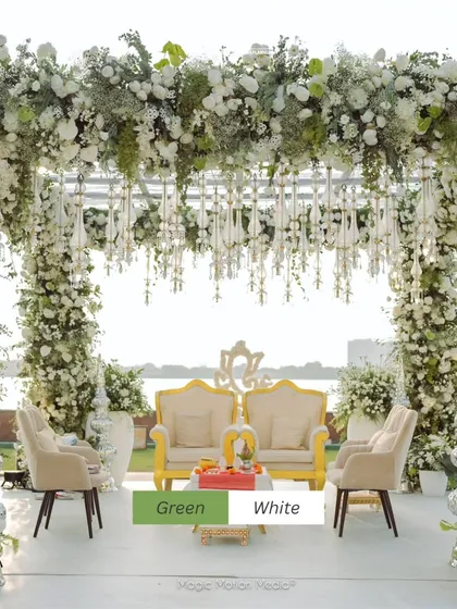 A serene green and white mandap set against a tranquil waterfront. The abundance of baby's breath and white roses created an ethereal atmosphere, perfect for a daytime wedding ceremony.