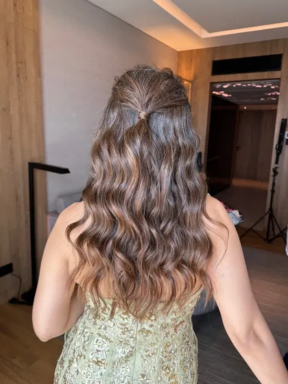 The back view of this simple yet stunning half-updo. A small section is pulled back, allowing the rest of the hair to cascade down in beautiful waves.