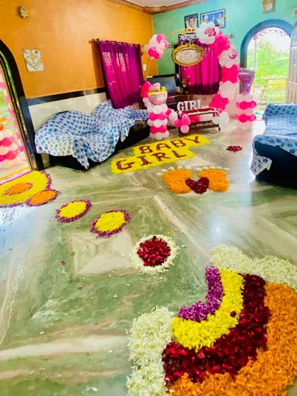 An artistic floor decoration using flower petals of various colors for a special baby welcome ceremony.