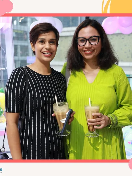 Two moms enjoying a coffee break while their kids play. This is what we're all about: providing a space where parents can relax and socialize, knowing their children are safe and entertained.