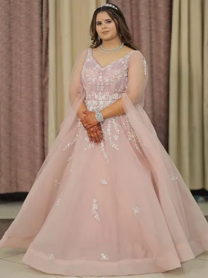 Feel like a princess in this beautiful pastel pink ball gown. With delicate silver embroidery on the bodice and sheer sleeves, this rental gown is a fantastic choice for an engagement, reception, or a pre-wedding photoshoot.