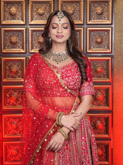 The complete look is a testament to our student's skill. They have perfectly balanced the bold red lehenga with makeup that is both glamorous and graceful.