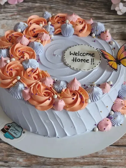 A "Welcome Home" cake with a beautiful arrangement of peach and lavender rosettes. It's a warm and sweet way to greet a loved one.