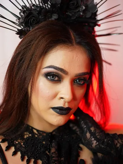 This shot highlights the dramatic headpiece and the intense, piercing gaze created with makeup and contact lenses.