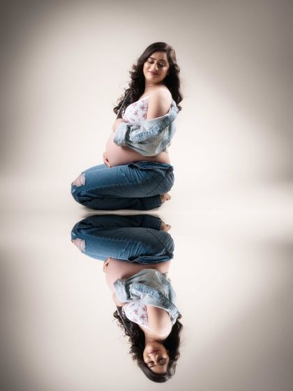 Reflections of love. This serene moment in a trendy shirt and jeans evokes a sense of tranquility, with her reflection symbolizing the profound mother-child connection.