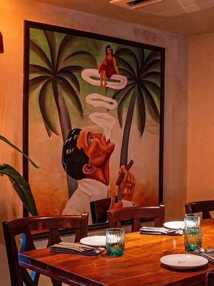 We love creating a specific mood with our art. This surreal painting, featuring a woman appearing in a puff of smoke, sets a cool, imaginative vibe for the dining area at Maze Concept.