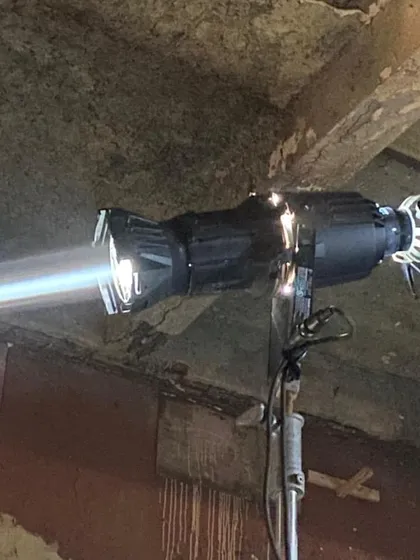A close-up of the K5600 Jokerbug 800 with a Bug-a-Beam adapter, creating a powerful, focused beam of daylight. This combination is a classic gaffer's tool for creating sharp, controllable shafts of light.
