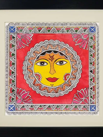 A vibrant depiction of the sun in Madhubani style by Anu Bansal. The use of bright red and yellow, along with lotus motifs, gives this traditional artwork a warm and auspicious feeling.