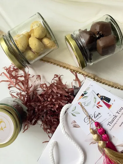 A closer look at our wedding return gift set, featuring jars of assorted panned nuts and a personalized thank you card with a decorative tassel.