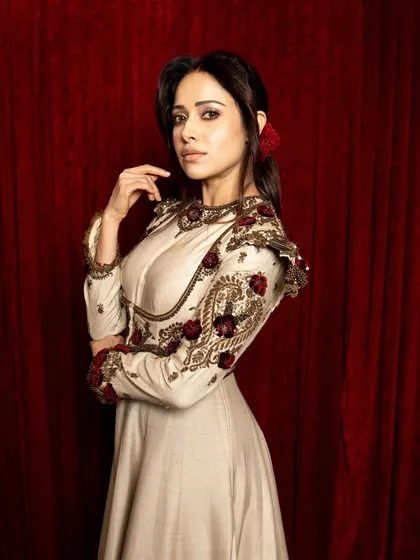 A side profile from the 'Umrao Jaan' set, highlighting the intricate embroidery on the sleeve and the traditional hair accessory.