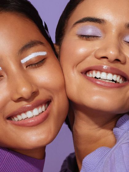 A beautiful close-up of two models, styled in coordinating shades of purple to create a harmonious and serene image for the skincare campaign.