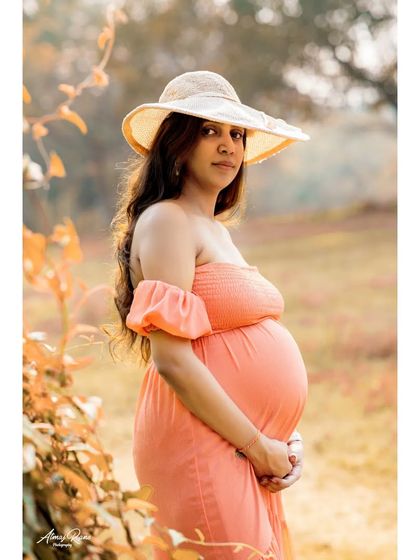 A side profile portrait that beautifully accentuates the baby bump. The soft backlighting and natural setting create a warm and flattering image.