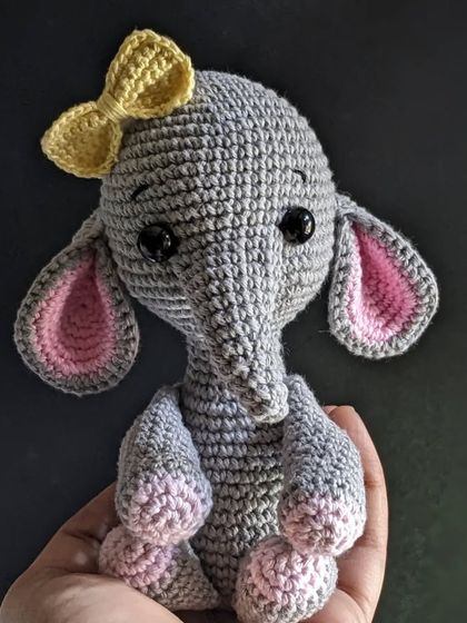 Holding the grey elephant plushie, a perfect handmade toy for kids.