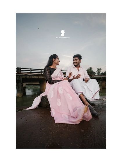 A candid moment of conversation between a couple during their outdoor shoot. The simple setting by a bridge allows their interaction to be the main focus.