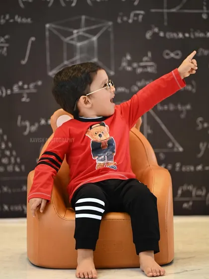 An expressive portrait of the child pointing upwards with excitement during his themed photoshoot.