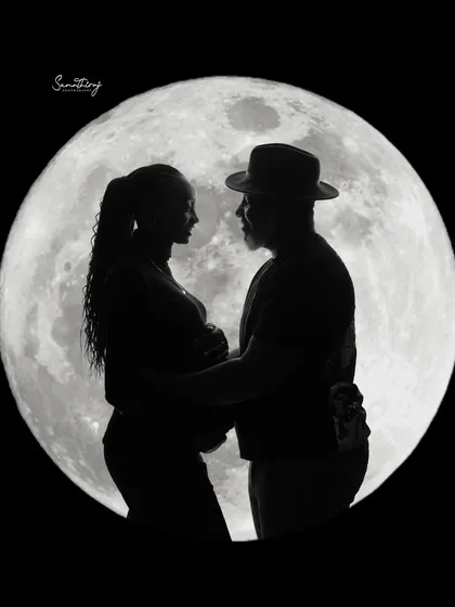 A romantic silhouette of a couple against a full moon. This classic and dramatic shot is a beautiful way to capture the love and anticipation of expecting parents.