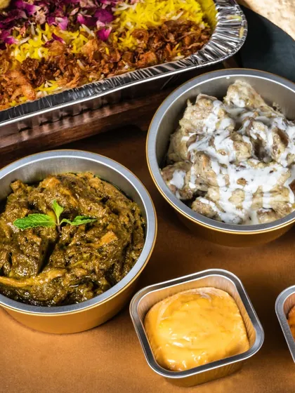 A feast for the eyes and the palate. This shows a bulk order of biryani alongside side dishes like Mutton Pahadi Keema and Malai Chicken.