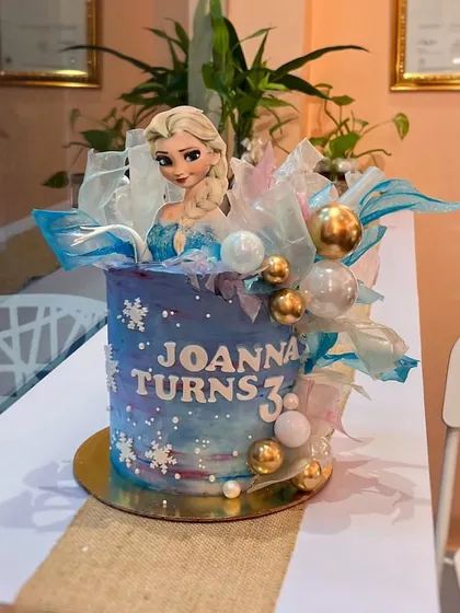 Let it go! A Frozen-themed cake for Joanna's third birthday. This design features a blue and purple watercolor effect, edible snowflakes, shimmering wafer paper sails, and an Elsa topper to bring the magic to life.